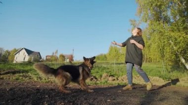 Genç kadın ile büyük köpek açık havada oynar, çoban köpeği kadar açık havada atlar, kadın büyük çoban ile parkta, insanlar hayvanlar, köpekle oynamayı çalış