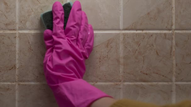 Primer plano de limpieza de la pared de baldosas sucias con la mano en guante de goma por esponja, comercial de productos químicos para el hogar, limpieza de la casa, barro y grasa — Vídeos de Stock