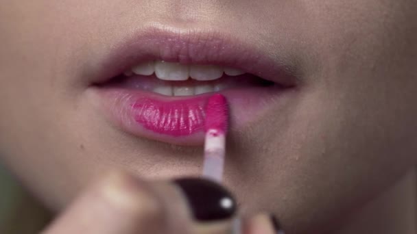 Rouge à lèvres sont appliqués sur les lèvres des femmes, faire du maquillage du soir lumineux, maquillage des lèvres, maquilleurs travaillent, fermer les lèvres, macro shot — Video