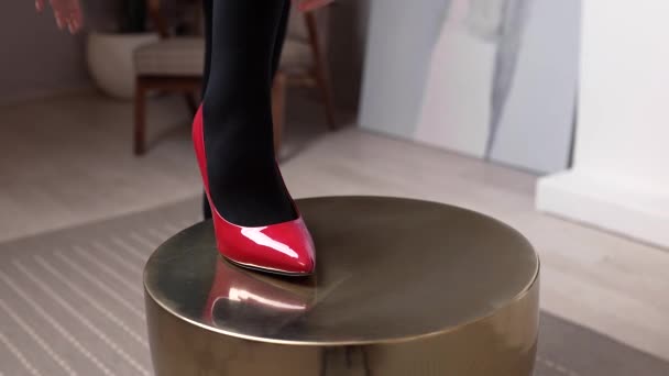 Femme en chaussures rouges passe sa main sur sa jambe en bas noirs, bonneterie femme, vêtements et accessoires pour femmes, look quotidien — Video