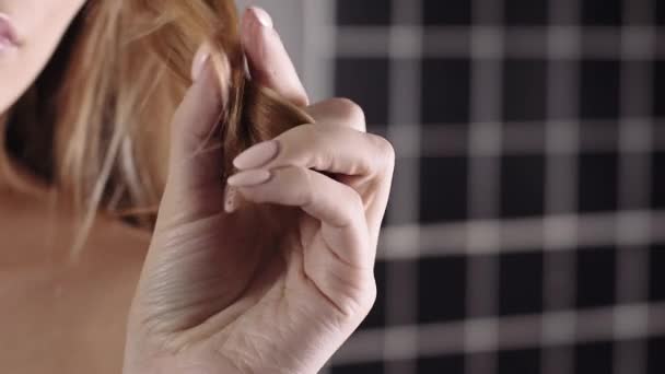 Donna tiene i capelli secchi fragili in una mano, cura dei capelli, shampoo e cosmetici per capelli forti, punte fragili — Video Stock