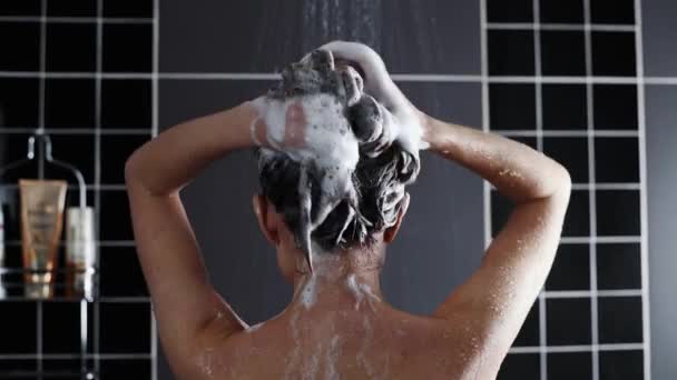 Woman washes her hair with shampoo in the shower with, hair care, ceratin mask, rinse shampoo and balm, strong hair, washing hair — Stock Video