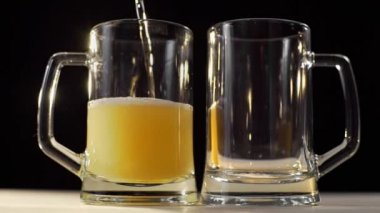 İki bira gözlük köpüklü altın light bira ile siyah arka plan, arkadaşı ile bira, içecekler, bira, 1080 p 60 fps kabarcıkları iki kişi için dökülür