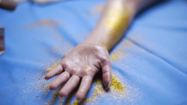 Gieten van de gloeiende sparkles aan de hand van de dames voor bodyart project, bodyart installatie, maken van de gloeiende glanzende make-up, fullhd slowmotion — Stockvideo