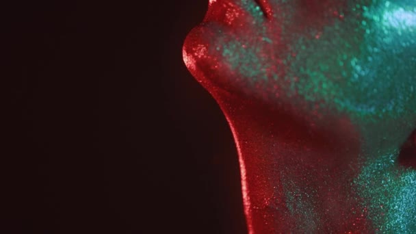 Mode porträtt av kvinna i glitter och under neon lights i 80s stil, video porträtt med gröna och röda blandade neon på mörk bakgrund, skjuten i hög kvalitet prores 422 på Blackmagic Ursa — Stockvideo