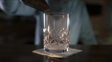 Barmen kokteyl yapmadan önce bardağa bazı buz ekler, alkol, bir barda taze soğuk içecekler yapma, barmen çalışması, 4k UHD ProRes HQ 422 60p