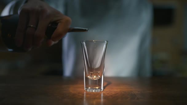 Nahaufnahme Video vom Einschenken von dunklem Alkohol in Zeitlupe in das Glas, Einschenken von Alkohol in eine Bar, Barkeeper bei der Arbeit, 4k uhd 60p prores hq 422 — Stockvideo