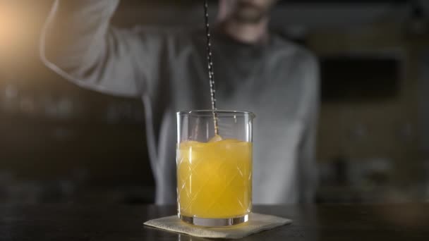 Bartender mixes cocktail ingredients with long bar spoon in slow motion, fresh drinks in the bar, mixing cocktails, 4k UHD 60p Prores HQ 422 — Stock Video