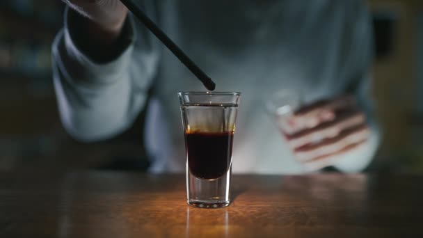 Ο μπάρμαν προσθέτει σιρόπι στο στρώμα με ποτό και τζιν σε αργή κίνηση, κάνοντας κοκτέιλ σε ένα μπαρ, ποτό αλκοόλ, μπαρ πάρτι, 4K UHD 60p βίντεο στο ProRes HQ 422 — Αρχείο Βίντεο