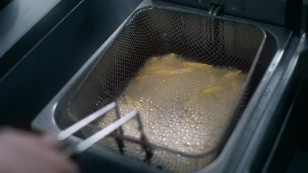 厨师将生土豆放入沸腾的油中，用于慢动作制作薯条，在快餐店制作炸薯条，烹饪土豆，脆薯条，4k Uhd 60p Prores Hq 422 — 图库视频影像