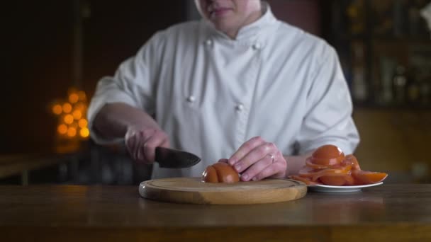 De kok snijdt verse rode tomaten op het houten bord in een bar in slow motion, verse vgetable salade koken, vegetarisch eten en maaltijden, 4k UHD 60p ProRes HQ 422 — Stockvideo