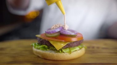 Şef sulu burger yapar ve içine baharatlı sos döker , fast food restoranda burger yapma, barbekü vurgers, 4k Uhd 60p Prores Hq 422