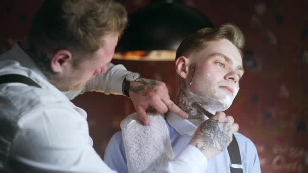 Tatuerade Barber rakar hans tatuerade klient med rakkniv, frisörsalong i 30s Mafia Style, rakning Salon, 4K UHD 60p ProRes HQ 422 — Stockvideo