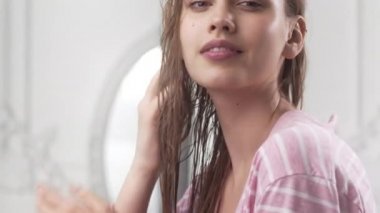 Bornozlu güzel kadın güneş ışığı ile aydınlatılmış sabah yatak odasında ıslak saçları na bir maske koyar, saç bakımı, mutlu sabah, günün başında, 4k Uhd Prores Hq 422