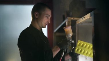 Adam egzoz kaputunda sprey tabancaile sarı renkte detay boyar, fabrika boyama, kapalı sprey tabanca ile çalışma, Full Hd Prores Hq 422 yavaş hareket