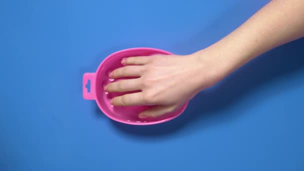 Женщина кладет руку в ванну для ногтей перед маникюром, подготовка к вырезанному маникюру, в салоне красоты, спа-салон для ногтей, 4k UHD Prores HQ 422 — стоковое видео