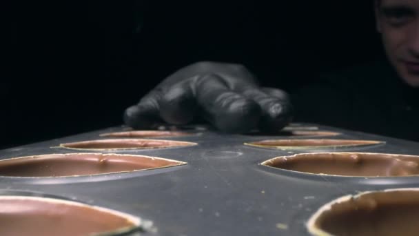 Chocolatier prepara moldes de chocolate antes de hacer dulces con relleno de chocolate líquido para dulces pralinicos, fabricación de dulces y barras de chocolate hechas a mano, full hd Prores HQ 422 — Vídeos de Stock