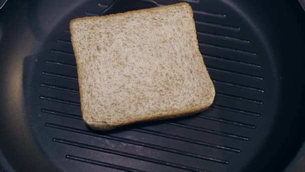 O cozinheiro vira torrada de lado a lado na panela de grelhar quente, fazendo o sanduíche, pão torrado, fast food caseiro, cozinhar em casa, lanches, Full HD Prores 422 HQ — Vídeo de Stock