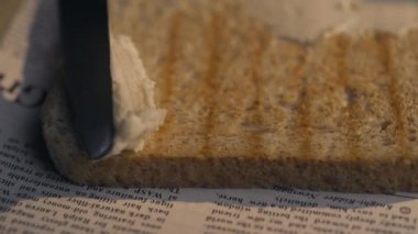 Yakın çekim: aşçı çıtır kavrulmuş tost ekmeği üzerine bıçakla tereyağı yayılır, sandviç yapma, ev yapımı fast food, evde yemek, aperatifler, Full Hd Prores 422 Hq