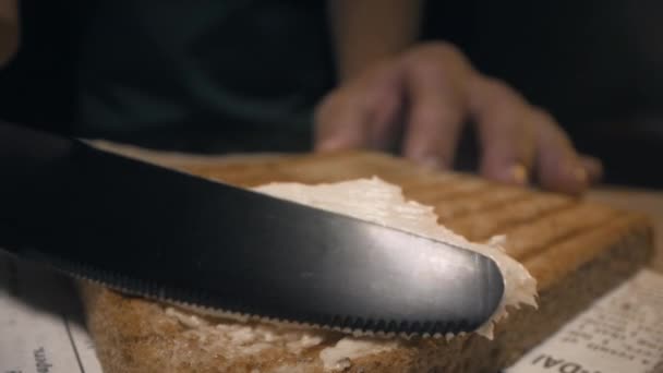 Bliska strzał: kucharz rozprzestrzenia się masło nożem na chrupiące pieczywo tostowe pieczone, co kanapkę, domowe Fast food, gotowanie w domu, przekąski, Full HD ProRes 422 HQ — Wideo stockowe