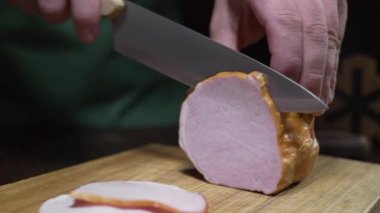 Lezzetli doğal jambon video yakın ahşap tahta üzerinde keskin bıçak tarafından dilimlenmiş, sarsıntılı füme et, dilimlenmiş jambon ile sandviç yapma, et pişirme, kasap dükkanında, Full HD ProRes HQ 422