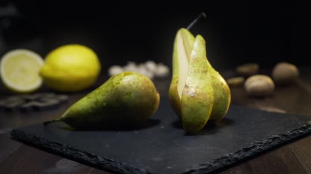 Slide zoom shot: pera jugosa cruda está en la mesa de la cocina, fruta fresca, ingredientes para ensalada de frutas, vitaminas dulces, Full HD Prores 422 HQ — Vídeo de stock