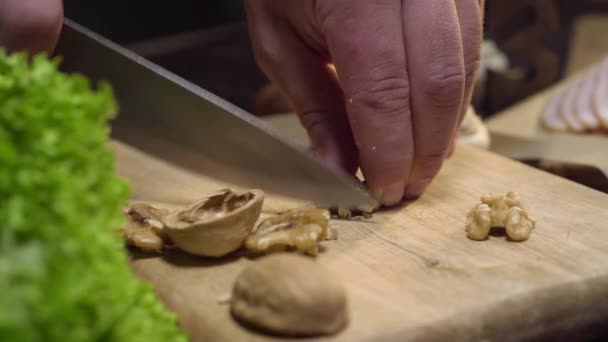 Close-up video: Chef snijdt walnoten op het houten bord, kook salade, vitamine vegetarisch eten, hakken van de noten, ingrediënten voor het koken, Full HD ProRes 422 HQ — Stockvideo