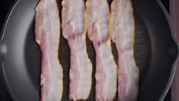 Flat Lay Shot av bitar av bacon rostas på den varma grillen Pan, slow motion skott av grillad bacon, skivor av kött på pannan, matlagning kött, ohälsosam läcker mat, full HD ProRes 422 HQ — Stockvideo