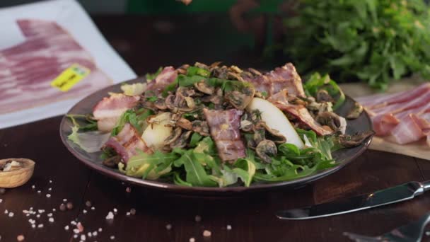 Chef voegt geroosterd schijfje spek toe aan de groente salade met vlees, gegrilde spek chips, vlees koken, maaltijd met greens, groenten en varkensvlees, Full HD ProRes 422 HQ — Stockvideo