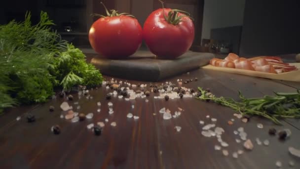 Διαφάνεια βίντεο δύο ώριμες κόκκινες ντομάτες είναι στην ακτίνα του φωτός στο τραπέζι της κουζίνας, συστατικά για σαλάτα λαχανικών, μαγειρική σάλτσα κέτσαπ, Full HD ProRes 422 HQ — Αρχείο Βίντεο