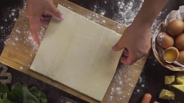 Flat lay shot: chef rolls out the dough with a rolling pin on the kitchen table, table top of the rolling out the puff pastry, eggs and flour, Full HD Prores 422 HQ — Stock Video
