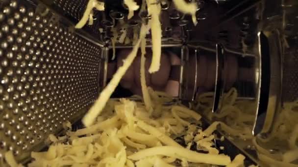 Vídeo macro de queso rallado, ver dentro del rallador, cerrar los alimentos, cocinar con queso rallado, dentro de los utensilios de cocina, Full HD Prores 422 HQ — Vídeo de stock