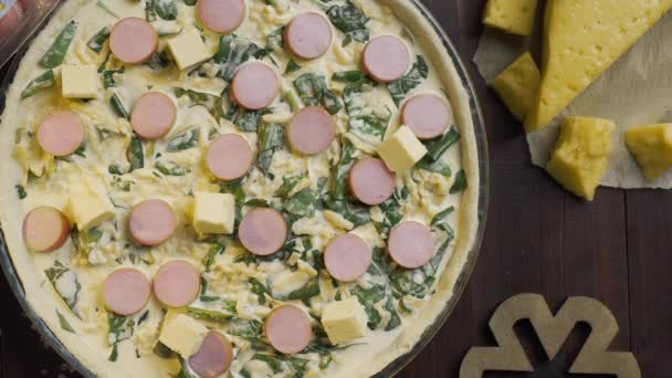 Flat lay video: the cook adds butter to the pie with cheese and sausages, tabletop video - preparing the pie before putting it to the hot oven, pizza and pastry, Full HD Prores 422 HQ — Stock Video