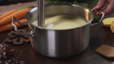 Aşçı metal tavada püresi çorbası yapmak için el blender kullanır, sağlıklı gıda pişirme, püre sebze, Full Hd Prores 422 Hq