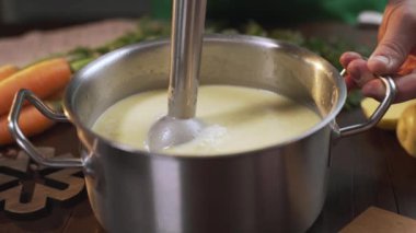 Aşçı metal tavada püresi çorbası yapmak için el blender kullanır, sağlıklı gıda pişirme, püre sebze, Full Hd Prores 422 Hq