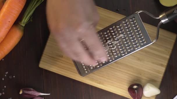 Flat lay shot: chef crates garlic on the small grater on the wooden board, cooking with spices, natural food, vegetable meal, spicy food, Full HD Prores 422 HQ — Stock Video