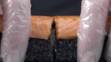 Şef siyah pirinç ve somon ile suşi rulo yarım böler, çiğ kırmızı balık pişirme, gevrek somon suşi rulo, Asya mutfağı, Full Hd 60fps Yavaş hareket Prores Hq 10 bit