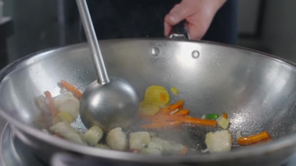 Chef fríe verduras con pescado en wok caliente en cámara lenta, cocina wok asiático, revolviendo en una sartén caliente, restaurante chino de comida rápida, cocina lenta mo, Full HD Prores HQ 10 bit in 240 fps — Vídeo de stock