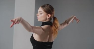 Siyah elbiseli çekici genç bayan dansçı açık arkadan dans hareketleri, bale provası, balerin sahne kostümüyle dans adımları, dans stüdyosu dersi, 4K 60p Prores HQ