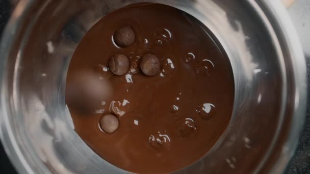 Επιτραπέζιο πλάνο: chef σοκολάτα σταγόνες τρούφες στο ζεστό λιωμένο σοκολάτα γάλακτος σε αργή κίνηση, ζαχαροπλάστης κάνει γλυκά σοκολάτας και καραμέλες, μαγείρεμα επιδόρπια με κακάο, 1080p 240fps Prores HQ — Αρχείο Βίντεο