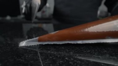 Şekerci, içinde erimiş çikolata olan pasta poşetinin ucunu keser, pasta süsleme hazırlıkları, yavaş çekim yemek videosu, tatlı tatlı ve şeker pişirme, FullHD 240 fps Prores