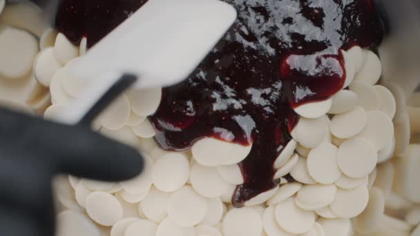 Tabletop-Video: Konditor mixt heiße Erdbeermarmelade und weiße geschmolzene Schokolade, Chocolatier produziert Bonbons und macht die Füllung für Kuchen, Full HD 240fps Proress HQ — Stockvideo