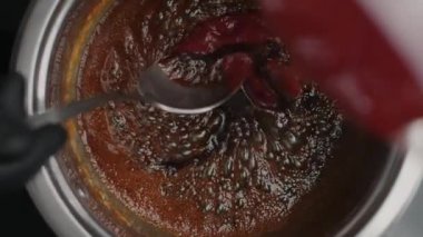 Masa başı yavaş çekim videosu: şef kaynamış karamelli metal kaseye çilek ezmesi ekler, sıcak tuzlu karamel yapar, kek için yemek yapar, tatlı ve şeker yapar, 1080p 240 fps Prores
