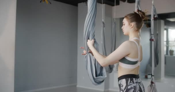 Aantrekkelijke jonge vrouw strekt zich uit en doet gymnastische oefeningen in de yoga studio, yoga lessen in slow motion, persoon maakt fysieke oefeningen, stretching en gymnastiek, 4k DCI 60p Prores HQ — Stockvideo