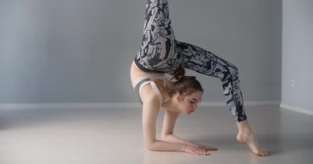 Çekici genç kadın öne eğilir ve yerde çeşitli yoga ve jimnastik egzersizleri yapar, insan fiziksel antrenman ve esneme yapar, yoga dersleri 4k 120p Prores karargahı 10 bit — Stok video