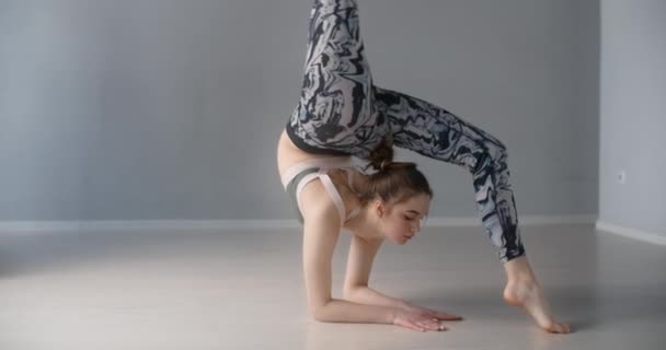 Atractiva joven se inclina hacia adelante y realiza varios ejercicios de yoga y gimnasia en el suelo, persona hace entrenamiento físico y estiramiento, clases de yoga 4k 120p Prores HQ 10 bit — Vídeos de Stock