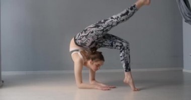 Çekici genç kadın öne eğilir ve yerde çeşitli yoga ve jimnastik egzersizleri yapar, insan fiziksel antrenman ve esneme yapar, yoga dersleri 4k 120p Prores karargahı 10 bit