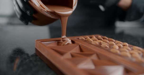 Chef confitero hace barra de chocolate - vierte chocolate caliente derretido a la forma de silicona, el arte del chocolate hecho a mano, postres de cocina de chocolate y cacao, haciendo barras, 4k 120 fps Prores HQ — Vídeo de stock