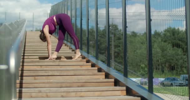 Atletisk kvinna gör stretching övningar på ledstänger av gatan trappor, fitness i stadsmiljö, yoga klass utomhus, fysisk träning i staden, 4k 60p Prores HQ — Stockvideo