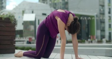 Kadın, yerleşim alanının bahçesindeki bankta esneme ve yoga egzersizleri yapıyor, şehir ortamında spor yapıyor, yoga sınıfında açık havada, şehirde fiziksel antrenman yapıyor, 4k 60p Prores karargahında.